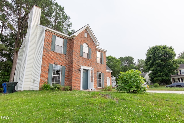 5200 Fieldwood Ct, Raleigh, NC 27616 - colonial home with a chimney, brick siding, and a front yard