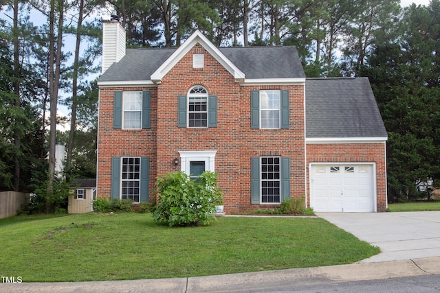 5200 Fieldwood Ct, Raleigh, NC 27616 - colonial-style house featuring a chimney, a front yard, driveway, brick siding, and roof with shingles