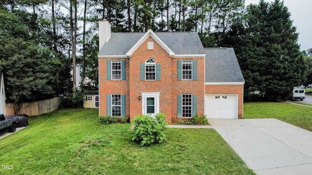 5200 Fieldwood Ct, Raleigh, NC 27616 - colonial house featuring a chimney, a garage, concrete driveway, and brick siding