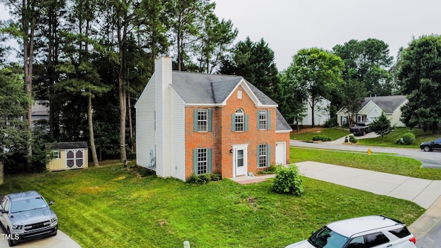 5200 Fieldwood Ct, Raleigh, NC 27616 - colonial home with brick siding, a chimney, a storage shed, a front lawn, and concrete driveway
