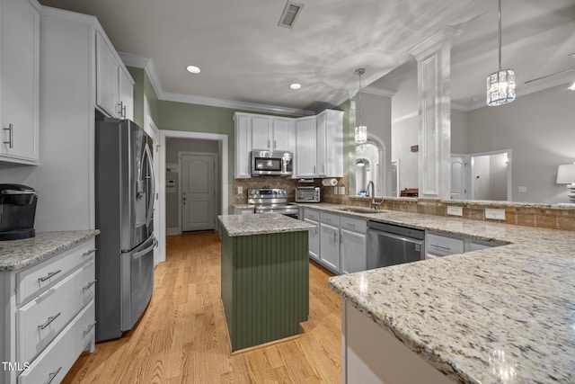 8116 Mosby Way, Willow Springs, NC 27592 - kitchen featuring stainless steel appliances, ornamental molding, light stone countertops, decorative backsplash, and a kitchen island