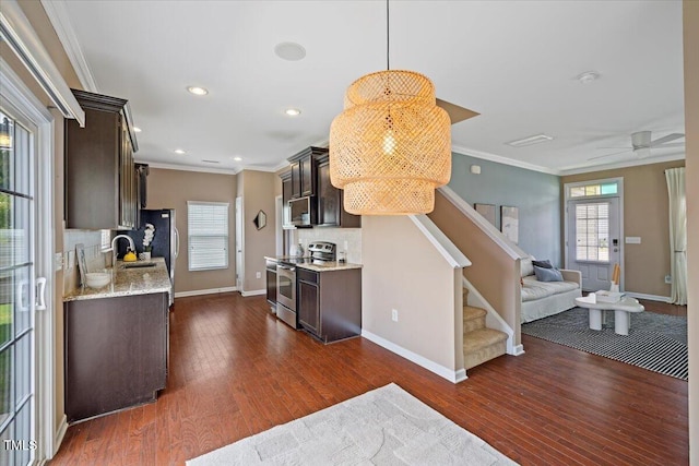 504 Gumview Cir, Fuquay Varina, NC 27526 - kitchen with stainless steel appliances, dark brown cabinetry, crown molding, dark wood-style flooring, and open floor plan
