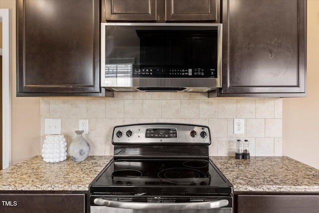 504 Gumview Cir, Fuquay Varina, NC 27526 - kitchen featuring stainless steel appliances, dark brown cabinets, decorative backsplash, and light stone counters