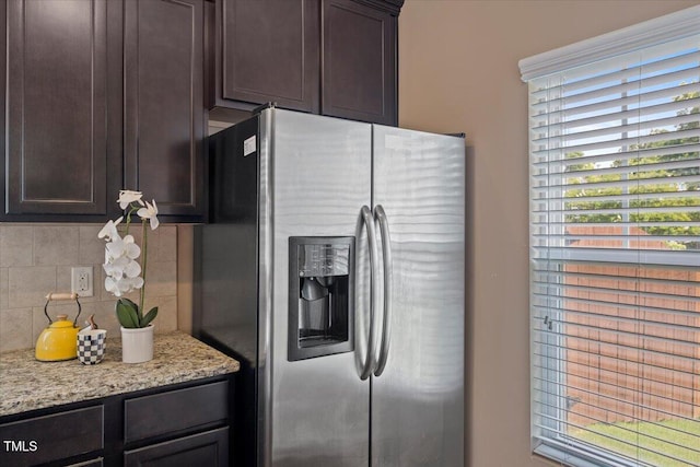 504 Gumview Cir, Fuquay Varina, NC 27526 - kitchen featuring stainless steel fridge with ice dispenser, tasteful backsplash, dark brown cabinets, and light stone counters