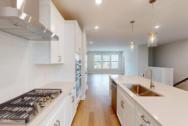 2735 Hunter Woods Dr # 571, Apex, NC 27502 - kitchen with wall chimney range hood, stainless steel appliances, light wood-style flooring, white cabinetry, and light countertops