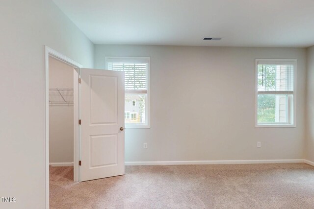 2735 Hunter Woods Dr # 571, Apex, NC 27502 - unfurnished bedroom with multiple windows, carpet, a spacious closet, and a closet
