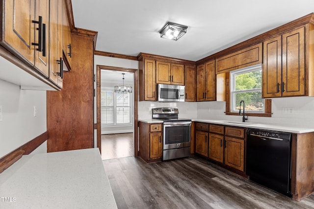 4408 Highmeadow Ln N, Wilson, NC 27896 - kitchen featuring stainless steel appliances, brown cabinets, dark wood-type flooring, a chandelier, and light countertops