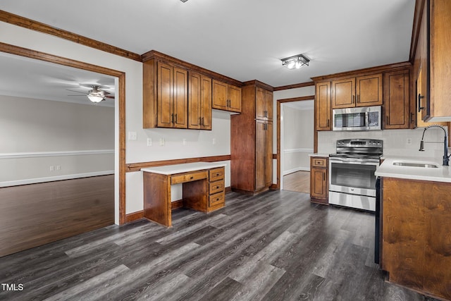 4408 Highmeadow Ln N, Wilson, NC 27896 - kitchen featuring appliances with stainless steel finishes, ornamental molding, dark wood finished floors, brown cabinets, and ceiling fan