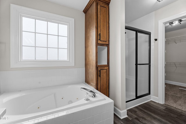 4408 Highmeadow Ln N, Wilson, NC 27896 - bathroom with a shower stall, a tub with jets, a walk in closet, and wood finished floors