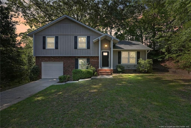 6405 Riegelwood St, Fayetteville, NC 28314 - split level home featuring driveway, a garage, brick siding, and a lawn