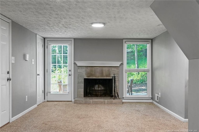 6405 Riegelwood St, Fayetteville, NC 28314 - unfurnished living room featuring carpet, a textured ceiling, and a tiled fireplace