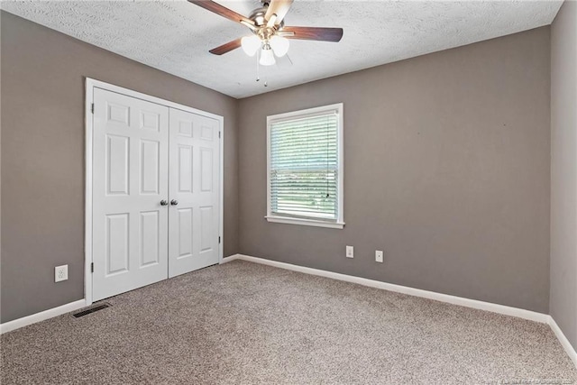6405 Riegelwood St, Fayetteville, NC 28314 - unfurnished bedroom with carpet flooring, a closet, a textured ceiling, and ceiling fan
