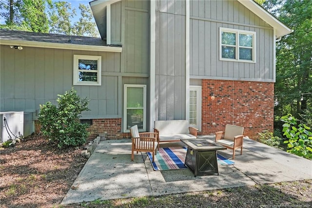 6405 Riegelwood St, Fayetteville, NC 28314 - rear view of property featuring brick siding, a patio area, an outdoor hangout area, and a shingled roof