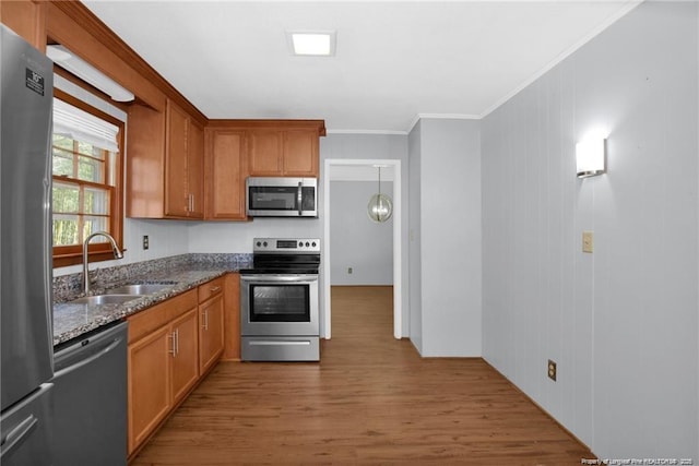 6411 Huntleigh Ct, Fayetteville, NC 28303 - kitchen featuring stainless steel appliances, wood finished floors, crown molding, dark stone countertops, and brown cabinets