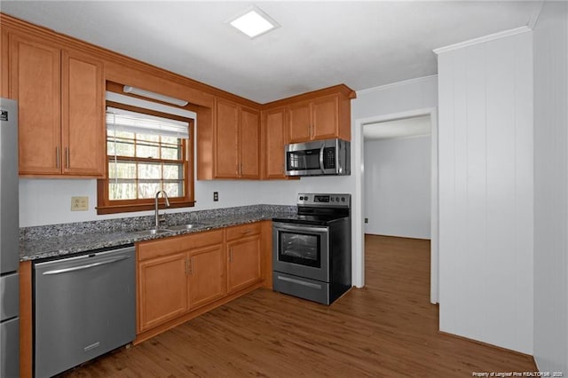 6411 Huntleigh Ct, Fayetteville, NC 28303 - kitchen featuring appliances with stainless steel finishes, dark wood finished floors, ornamental molding, dark stone counters, and brown cabinetry