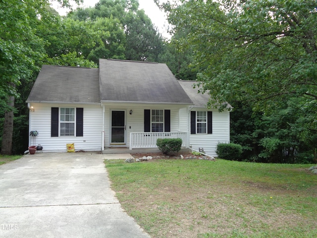 221 Hickory Glen Ln, Durham, NC 27703 - cape cod-style house with a porch, concrete driveway, a front lawn, and a shingled roof