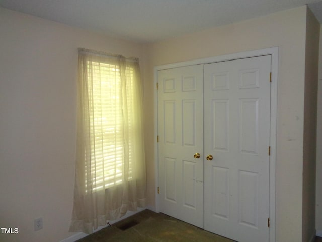 221 Hickory Glen Ln, Durham, NC 27703 - unfurnished bedroom featuring a closet and multiple windows