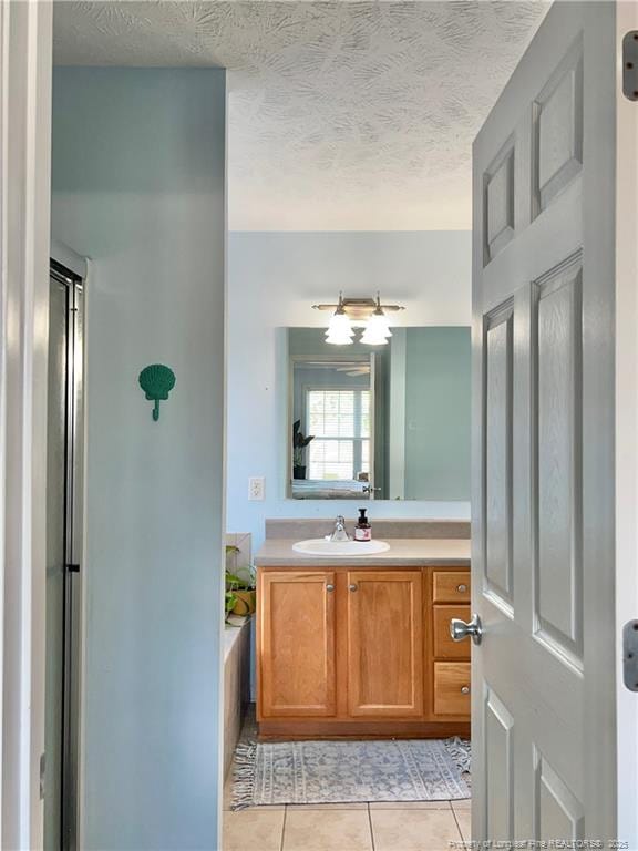 3401 Connection Dr, Fayetteville, NC 28311 - full bathroom with tile patterned flooring, vanity, a shower with door, a textured ceiling, and a bath