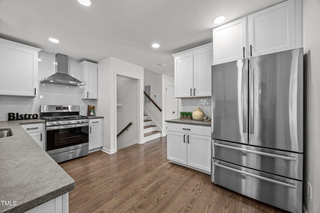 2317 Bertie Dr, Raleigh, NC 27610 - kitchen with stainless steel appliances, wall chimney exhaust hood, white cabinets, backsplash, and recessed lighting