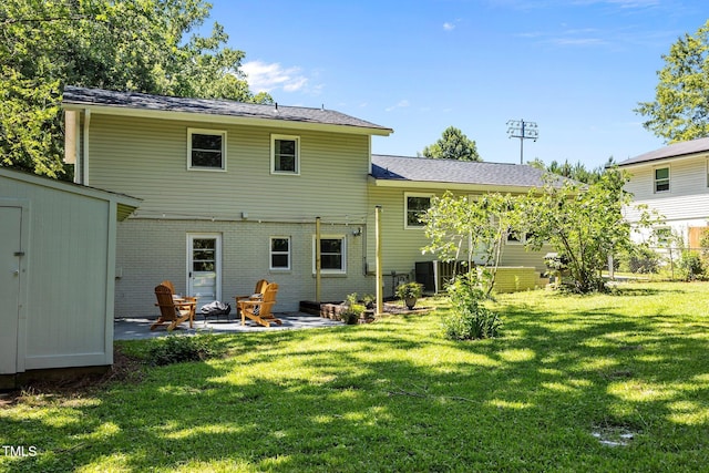 2317 Bertie Dr, Raleigh, NC 27610 - rear view of house featuring a patio area, brick siding, a storage shed, and a lawn