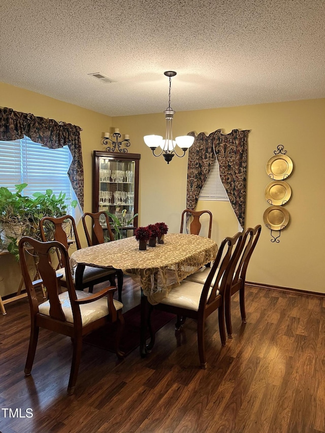469 Whitehead Rd, Enfield, NC 27823 - dining room with a chandelier, a textured ceiling, and dark wood-style flooring