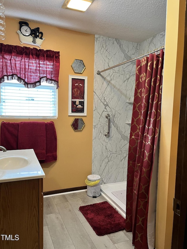 469 Whitehead Rd, Enfield, NC 27823 - bathroom with a textured ceiling, a stall shower, vanity, and wood finished floors