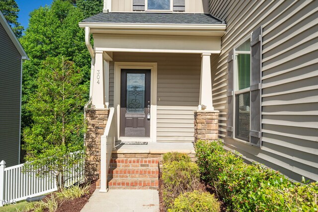 304 Garden Walk Dr, Durham, NC 27703 - view of exterior entry with a shingled roof and stone siding
