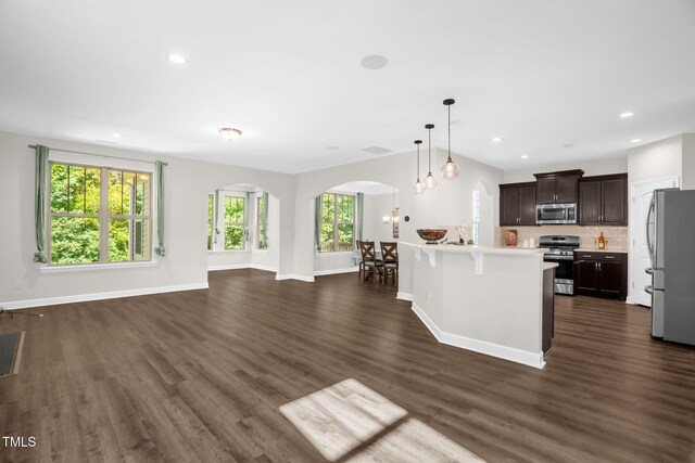 304 Garden Walk Dr, Durham, NC 27703 - kitchen with appliances with stainless steel finishes, arched walkways, open floor plan, light countertops, and dark wood-style floors