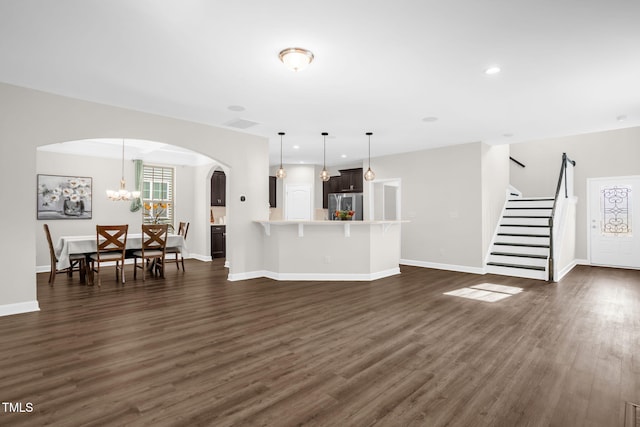 304 Garden Walk Dr, Durham, NC 27703 - unfurnished living room featuring arched walkways, dark wood finished floors, stairs, and recessed lighting