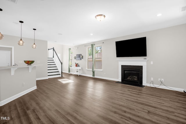 304 Garden Walk Dr, Durham, NC 27703 - unfurnished living room featuring stairway, dark wood-style floors, a fireplace with flush hearth, and recessed lighting