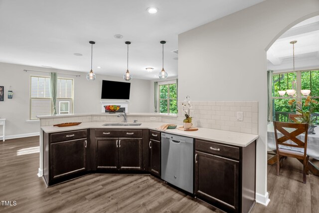 304 Garden Walk Dr, Durham, NC 27703 - kitchen with stainless steel dishwasher, wood finished floors, backsplash, a peninsula, and arched walkways