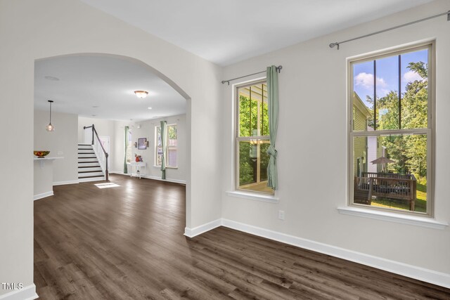 304 Garden Walk Dr, Durham, NC 27703 - spare room with arched walkways, stairs, and dark wood-type flooring