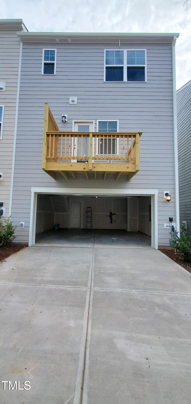 1426 Rosepine Dr, Cary, NC 27519 - rear view of house with an attached garage, concrete driveway, and a balcony
