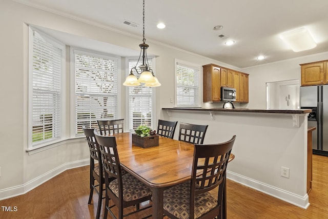 400 Indian Elm Ln, Cary, NC 27519 - dining area with crown molding, wood finished floors, and recessed lighting
