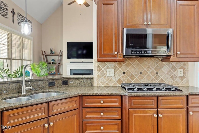 10012 San Remo Pl, Wake Forest, NC 27587 - kitchen with appliances with stainless steel finishes, vaulted ceiling, tasteful backsplash, light stone counters, and a ceiling fan
