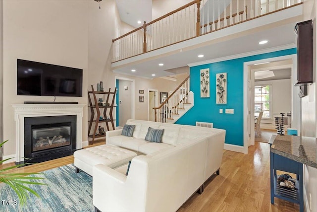 10012 San Remo Pl, Wake Forest, NC 27587 - living area with a towering ceiling, stairs, light wood-type flooring, ornamental molding, and recessed lighting