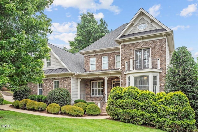 10012 San Remo Pl, Wake Forest, NC 27587 - view of front of house featuring covered porch, a balcony, brick siding, a standing seam roof, and roof with shingles
