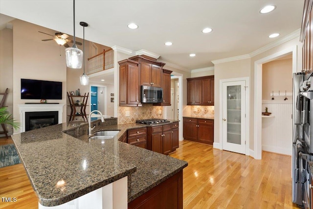 10012 San Remo Pl, Wake Forest, NC 27587 - kitchen featuring stainless steel appliances, ceiling fan, open floor plan, ornamental molding, and light wood finished floors