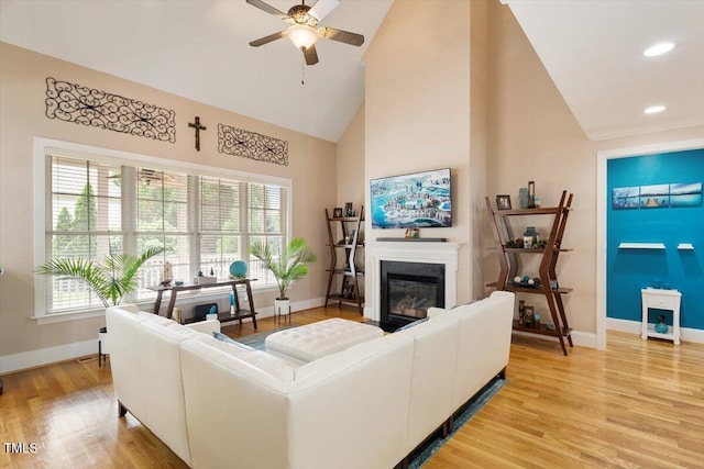 10012 San Remo Pl, Wake Forest, NC 27587 - living area with high vaulted ceiling, a ceiling fan, a glass covered fireplace, plenty of natural light, and light wood finished floors
