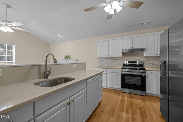 100 W Acres Cres, Cary, NC 27519 - kitchen with appliances with stainless steel finishes, ceiling fan, under cabinet range hood, backsplash, and vaulted ceiling