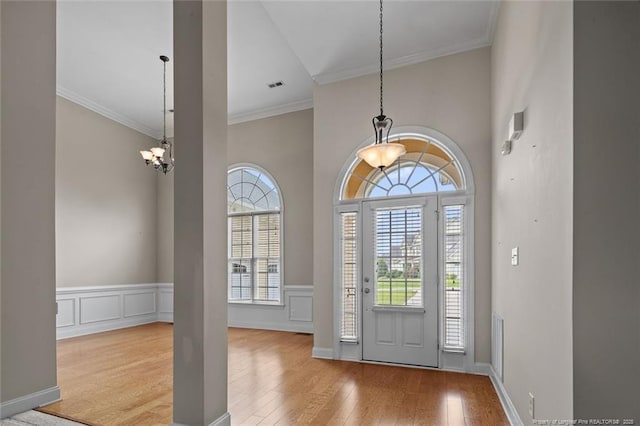 259 Rolling Pines Dr, Spring Lake, NC 28390 - foyer featuring wood finished floors, ornamental molding, a chandelier, wainscoting, and a decorative wall