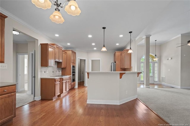 259 Rolling Pines Dr, Spring Lake, NC 28390 - kitchen with crown molding, a breakfast bar area, appliances with stainless steel finishes, light countertops, and tasteful backsplash