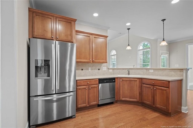 259 Rolling Pines Dr, Spring Lake, NC 28390 - kitchen featuring stainless steel appliances, ornamental molding, a peninsula, brown cabinets, and light countertops