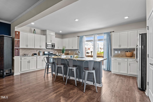 417 Austin View Blvd, Wake Forest, NC 27587 - kitchen featuring stainless steel appliances, white cabinetry, decorative backsplash, light stone countertops, and a breakfast bar area
