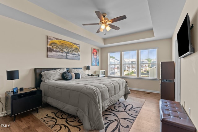 417 Austin View Blvd, Wake Forest, NC 27587 - bedroom featuring wood finished floors, a tray ceiling, and ceiling fan