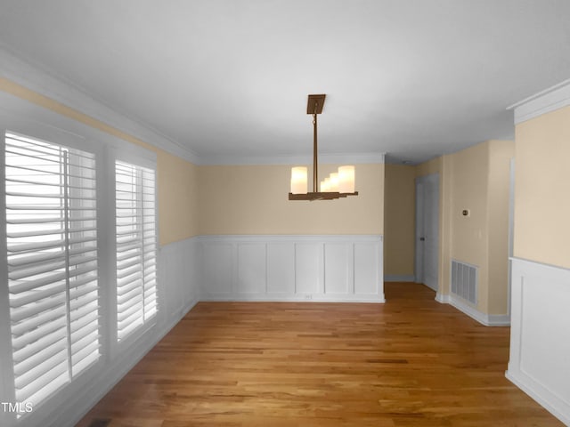 495 Ruth Cir, Fuquay Varina, NC 27526 - unfurnished dining area featuring light wood-style floors, ornamental molding, and a wainscoted wall