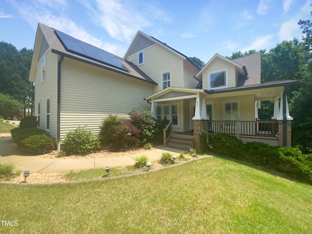 495 Ruth Cir, Fuquay Varina, NC 27526 - view of front of property featuring a front yard, roof mounted solar panels, covered porch, and roof with shingles