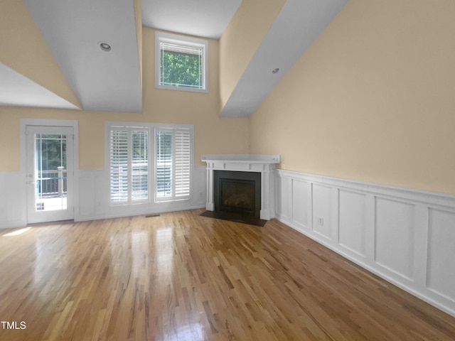 495 Ruth Cir, Fuquay Varina, NC 27526 - unfurnished living room with a decorative wall, a wainscoted wall, light wood-style floors, and a fireplace with flush hearth