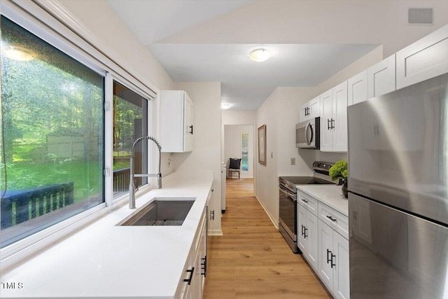 1403 Meadow Ln, Chapel Hill, NC 27516 - kitchen with appliances with stainless steel finishes, light wood-style floors, white cabinetry, and light countertops
