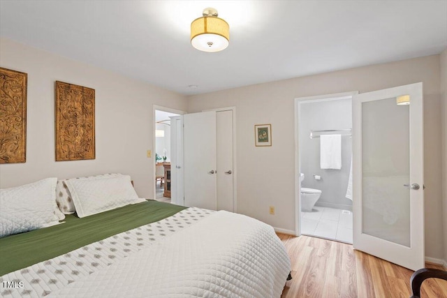 1403 Meadow Ln, Chapel Hill, NC 27516 - bedroom featuring connected bathroom, light wood-style floors, french doors, and a closet